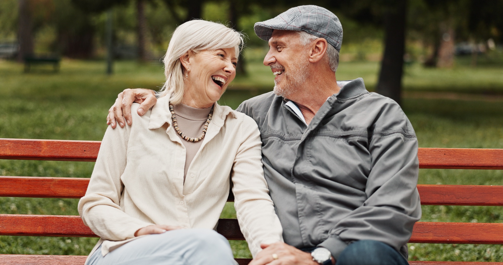 Senior couple, hug and laughing in park for bonding, conversation and commitment together outdoors.